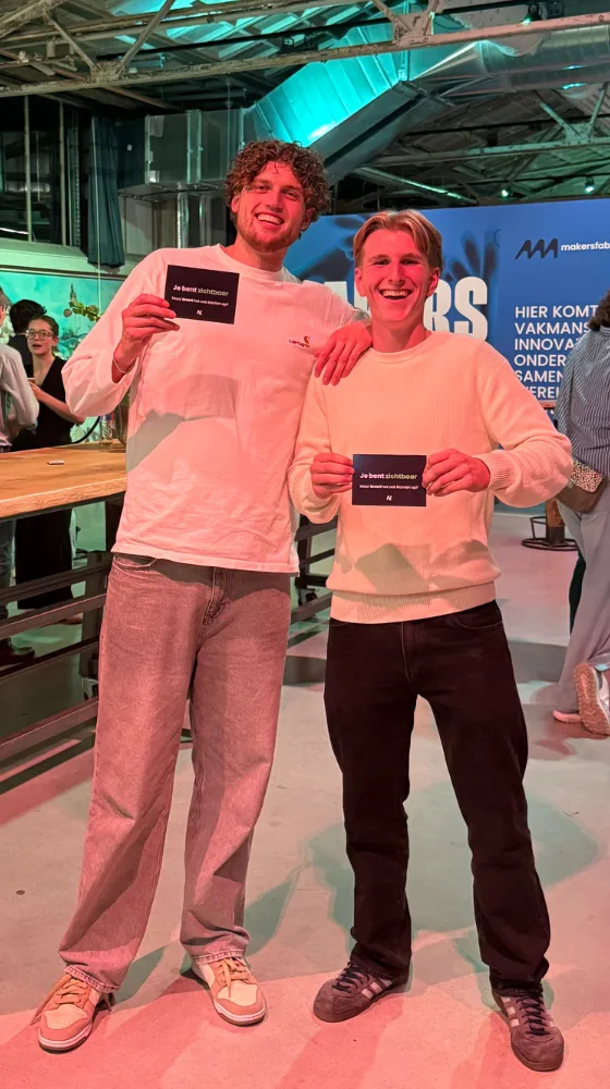 Bas en Daniel van Nuzichtbaar met hun kaartjes op een netwerkavond