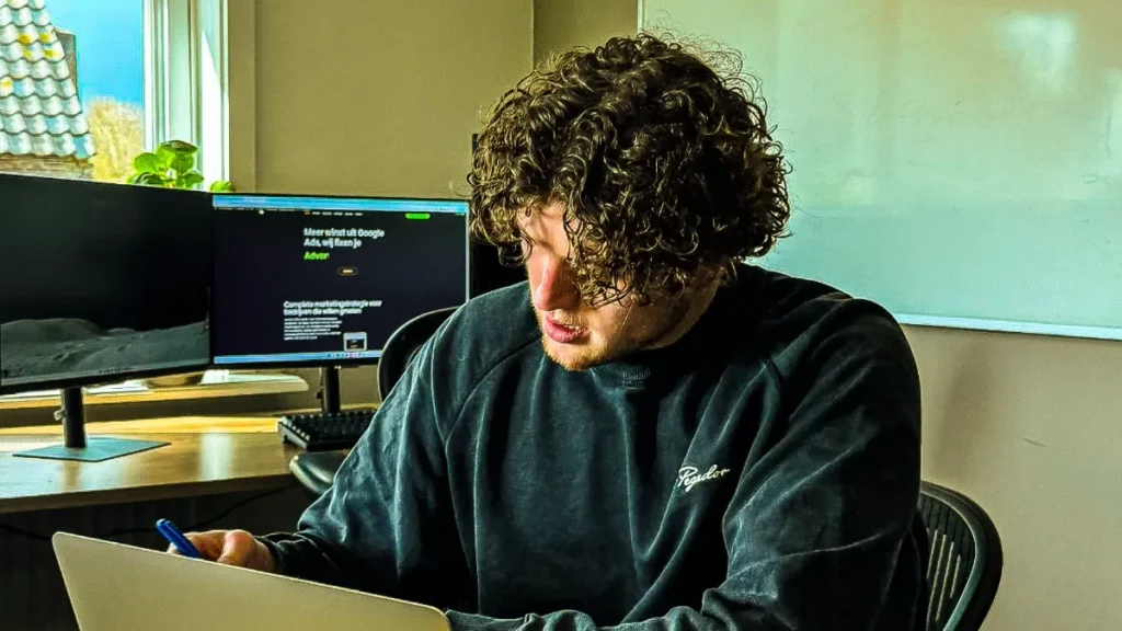 Bas van Nuzichtbaar rekent aan de Google Ads kosten van een campagne op zijn laptop